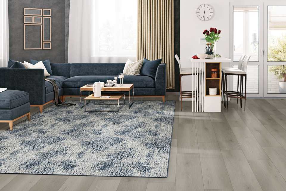 blue animal print area rug in living room with grey walls and blue velvet couch